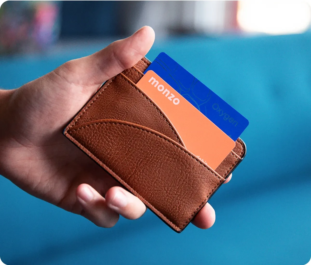 una mano sosteniendo una billetera que muestra las tarjetas dentro.